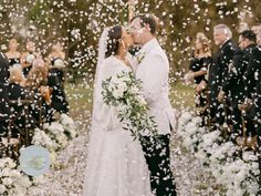 a newly married couple kissing under confetti