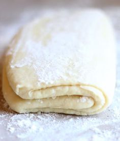 two uncooked pizza doughs sitting on top of a table covered in powdered sugar