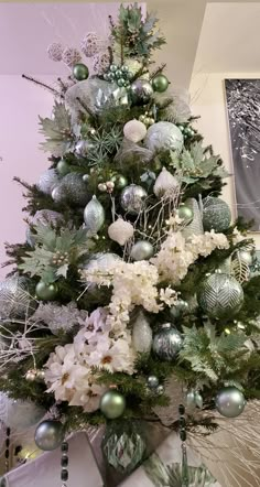 a christmas tree decorated with silver and white ornaments