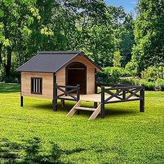 a dog house in the middle of a grassy field with a picnic table next to it