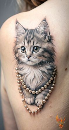 a woman with a cat tattoo on her shoulder and chest is wearing pearls around her neck