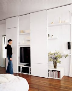 a woman standing in front of a white entertainment center