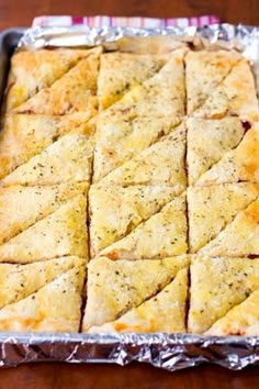 a pan filled with crackers sitting on top of a wooden table next to a knife