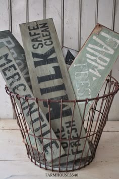 a wire basket filled with wooden signs sitting on top of a table