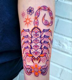 a colorful tattoo design on the arm of a woman's left arm, with an orange and purple crab