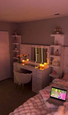 a laptop computer sitting on top of a bed in a room with candles lit up