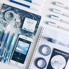 the contents of a travel kit laid out on top of a white table with pens, scissors and other items