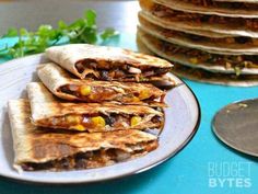 a stack of tortillas sitting on top of a white plate next to a pile of pancakes