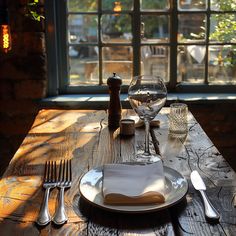 the table is set with silverware, wine glasses, and napkins on it