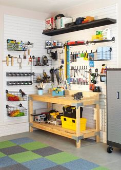 an image of a workbench with tools on the wall and shelves above it