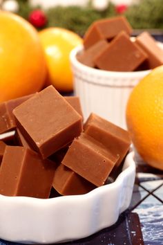 a bowl filled with chocolate next to oranges