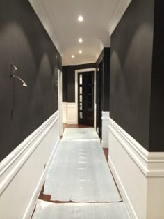 an empty hallway with black walls and white trim