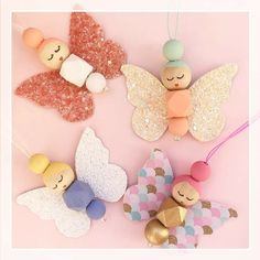 three small wooden angel ornaments on a pink background