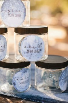 mason jars filled with moon dough sitting on top of a table