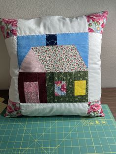 a quilted pillow sitting on top of a cutting board