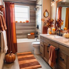 a bathroom decorated for fall with pumpkins and candles