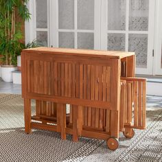 two wooden tables sitting on top of a rug next to a potted planter