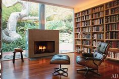 a living room filled with furniture and a fire place in front of a book shelf