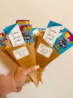 a person holding some brown envelopes with cards on them and writing on the envelope