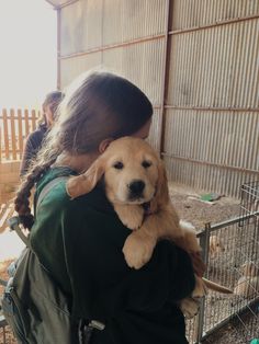 a woman holding a puppy in her arms