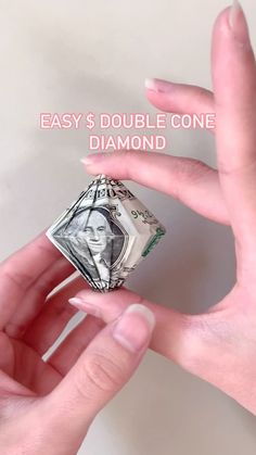 a hand holding a money origami piece with the words easy $ 3 double cone diamond