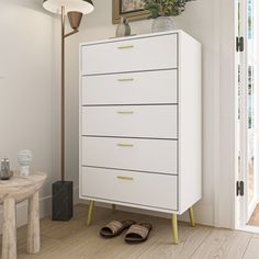 a white chest of drawers in a room with a painting on the wall behind it