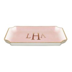 a pink and gold tray with the letter h on it's side, in front of a white background