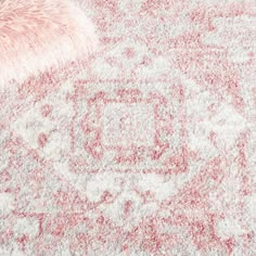 an area rug with pink and white colors