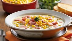 a bowl of corn chowee with ham and broccoli in it on a table