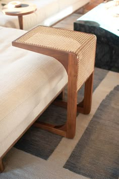 a wooden bench sitting on top of a rug in a living room next to a couch