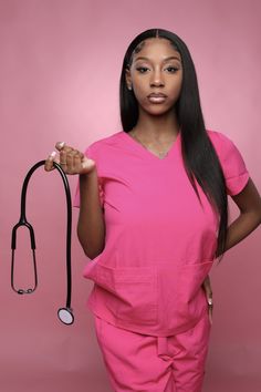 a woman in pink scrubs holding a stethoscope