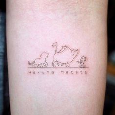 a small tattoo on the arm of a woman with three cats and one dog in it