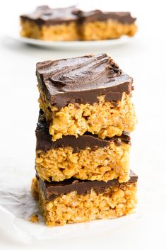 three pieces of chocolate peanut butter bars stacked on top of each other