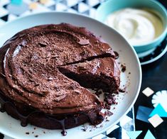 a chocolate cake on a plate with a slice missing