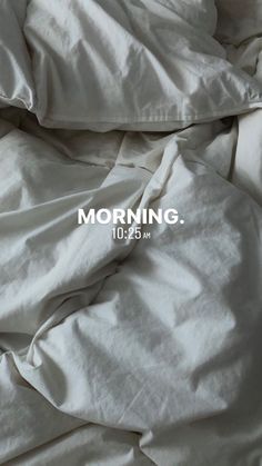 an unmade bed with white sheets and the words morning written on it in black