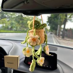 a car dashboard with a crocheted flower hanging from it's center console