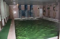 an indoor swimming pool with green water