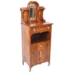 an antique wooden cabinet with a mirror on top