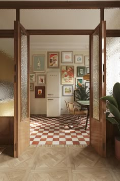 an open door leading to a kitchen with pictures on the wall and a checkered floor