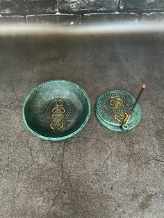 two green plates with gold designs on them