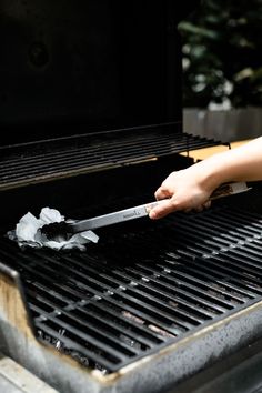 a person using a knife to cut up something on top of a grill