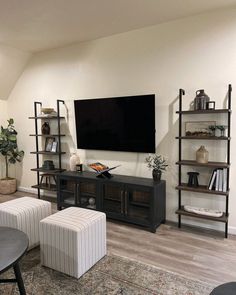 a living room filled with furniture and a flat screen tv mounted to the side of a wall