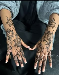 a woman's hands with tattoos on them