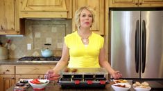 a woman standing in front of a counter with food on it