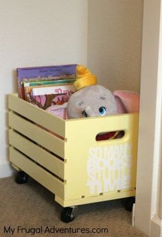 a stuffed animal sitting in a yellow crate on top of a floor next to a wall