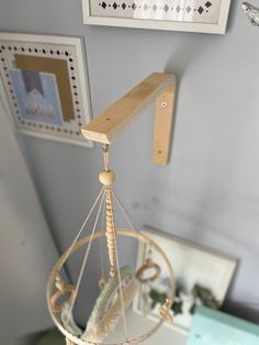 a baby crib hanging from the ceiling in a room with pictures on the wall