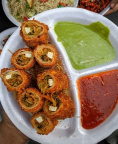 a plate filled with different types of food on top of a white plate next to sauce