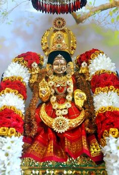 the statue is decorated with red and white flowers