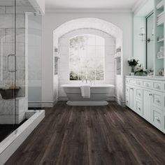 a large bathroom with wood floors and white fixtures