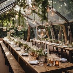 a long table is set with candles, plates and place settings for an outdoor dinner